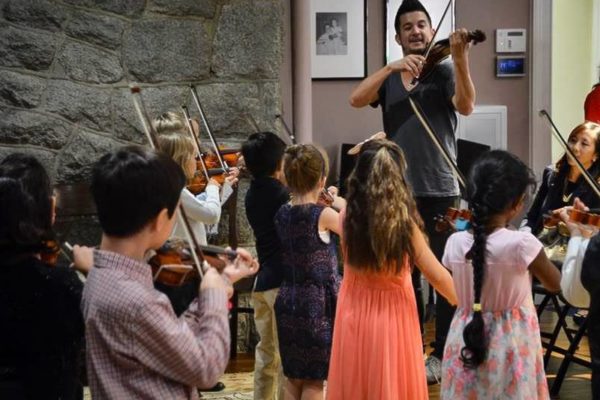 Violinist Nick Kendall teaching children.